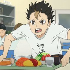 an anime character sitting at a table with food in front of him