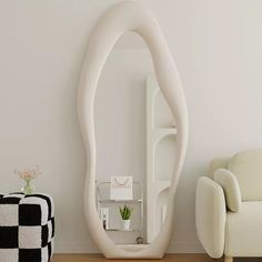 a living room with a couch, chair and large white mirror in it's corner