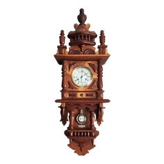 a wooden clock hanging from the side of a wall