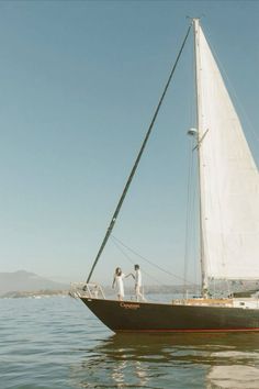 two people on a sailboat in the water