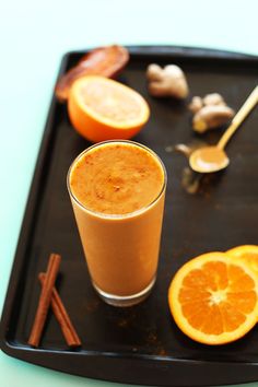 an orange smoothie on a tray with cinnamon sticks