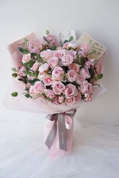 a bouquet of pink roses on a white background with some greeting cards in the corner