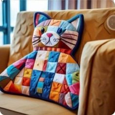 a colorful cat pillow sitting on top of a chair