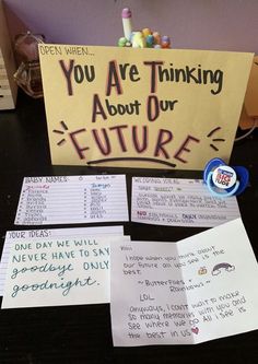 a table topped with lots of writing and notes on it's side, next to a sign that says you are thinking about our future