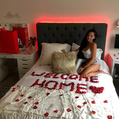 a woman sitting on top of a bed in a room with red lights and decorations