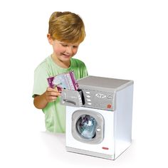 a young boy is playing with a washing machine and holding a card in front of it