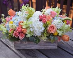 an arrangement of flowers in a wooden box