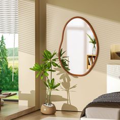 a bedroom with a bed, mirror and potted plant on the floor in front of it