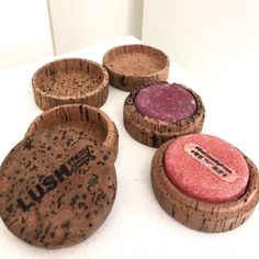 four wooden bowls with different colored pigments on them sitting on a white counter top