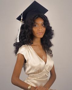 a woman in a graduation cap and gown posing for a photo with her hand on her hip