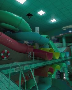 an indoor swimming pool filled with water slides