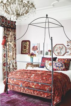 a canopy bed in a bedroom with red and white decor