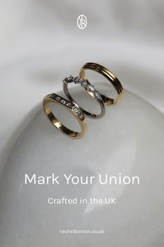 two gold wedding rings sitting on top of each other with the words mark your union crafted in the uk