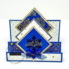 a blue and white christmas card with snowflakes on the front, gold trimmings