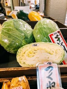 cabbages and other vegetables are on display in a grocery store