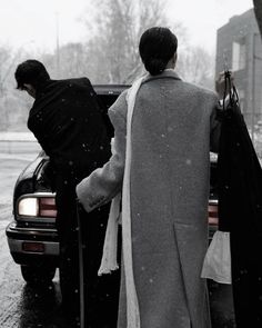 two people walking out of a car in the snow