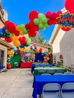 an outdoor party with balloons and tables