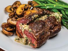 steak with mushrooms and green beans on a white plate