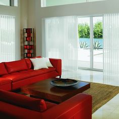 a living room with red couches and sliding glass doors