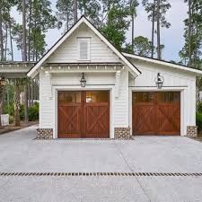 a white house with two brown garage doors