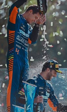 two men standing next to each other in front of confetti and confetti cups