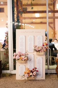 a table with flowers and seating cards on it