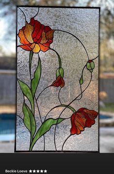 a stained glass window with flowers and leaves in the center, next to a pool