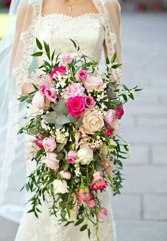 a bride holding a bouquet of pink and white flowers