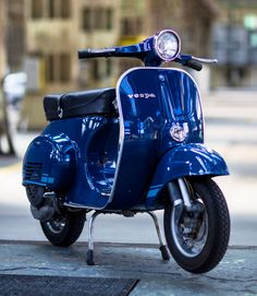 a blue scooter is parked on the sidewalk