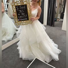 a woman in a wedding dress holding up a sign