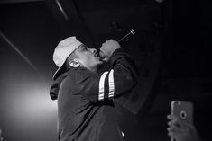 a man standing on top of a stage holding a microphone in front of his face