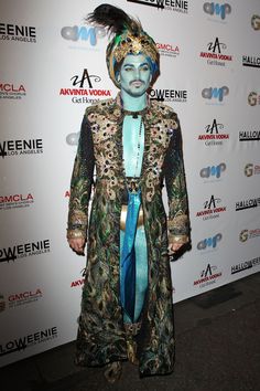 a man dressed in costume on the red carpet at an awards event with his face painted blue and gold