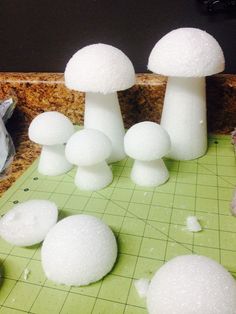 some white mushrooms sitting on top of a green cutting board