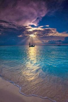 a boat floating on top of the ocean under a cloudy sky