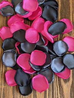 pink and black flowers on a wooden surface with one flower in the center surrounded by other petals