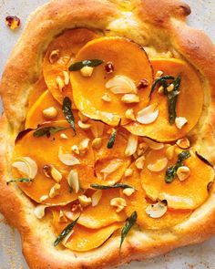 an uncooked pizza topped with sliced peaches and almonds