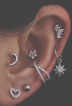 a woman wearing ear piercings with stars and moon designs