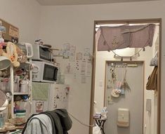 a room filled with lots of clutter next to a microwave and other things on the wall