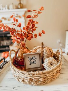 a basket filled with orange flowers on top of a white table next to a fireplace