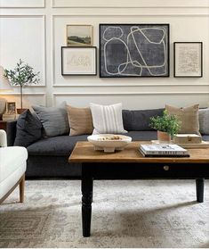 a living room filled with furniture and pictures hanging on the wall above it's coffee table