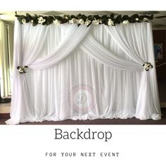 the back drop for your next event with white drapes and flowers on it's side