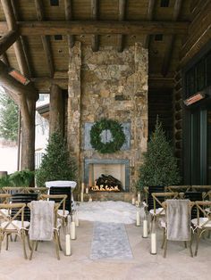 an outdoor dining area with chairs, tables and a fire place in the middle of it