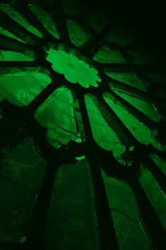 a green stained glass window in a dark room