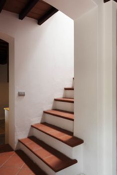 a set of stairs leading up to an open door in a home with tile flooring