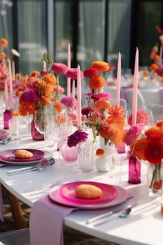 the table is set with pink and orange flowers