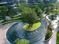 an aerial view of a park with many trees and water features in the center, surrounded by apartment buildings