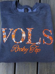 Embroidered Floral Tennessee Sweatshirt sweatshirt for TN fans.  Beautiful floral embroidery is orange and white with Rocky Top embroidered below with orange thread.  Stay cozy and warm while showing your team spirit.  Perfect for tailgating, wearing out or watching the game with friends.  Other colors and customizations available, please contact me for information. Material: 8 oz., 50% USA cotton, 50% polyester Pill-resistant air jet yarn Made with 50% sustainably and fairly grown USA cotton Tennessee Sweatshirt, Tn Football, Tennessee Football, Rocky Top, Football Game, Embroidered Tshirt, Embroidered Sweatshirts, Football Games, Floral Shirt