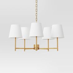 four light brass chandelier with white shades on the bottom and gold chain around it