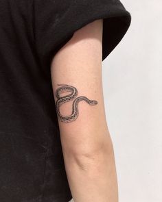 a woman's arm with a snake tattoo on the left side of her arm