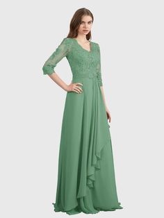 a woman in a long green dress with sheer sleeves and lace detailing on the shoulders